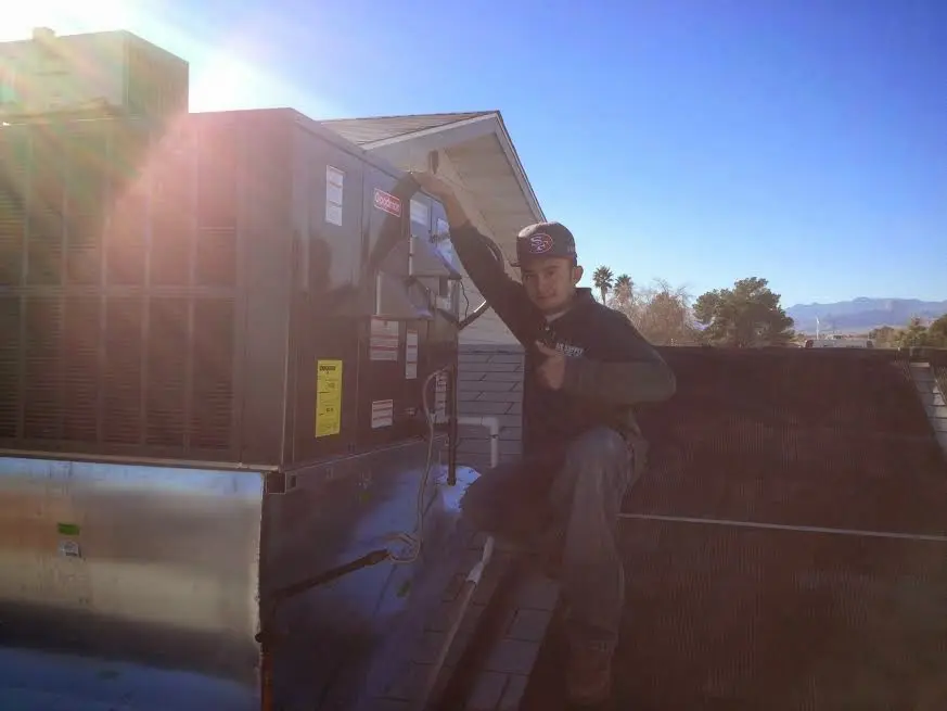 HVAC technician performing Air Duct Cleaning on a rooftop unit in Rio del Mar